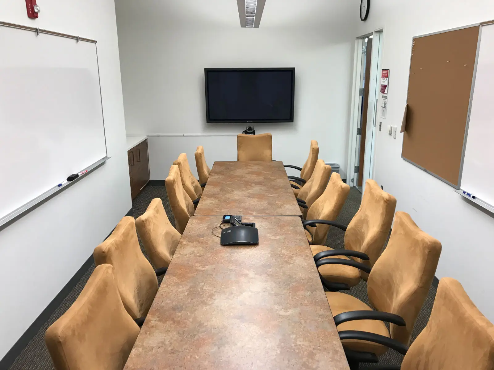 Two rows of chairs and table in a small Harmony campus conference room