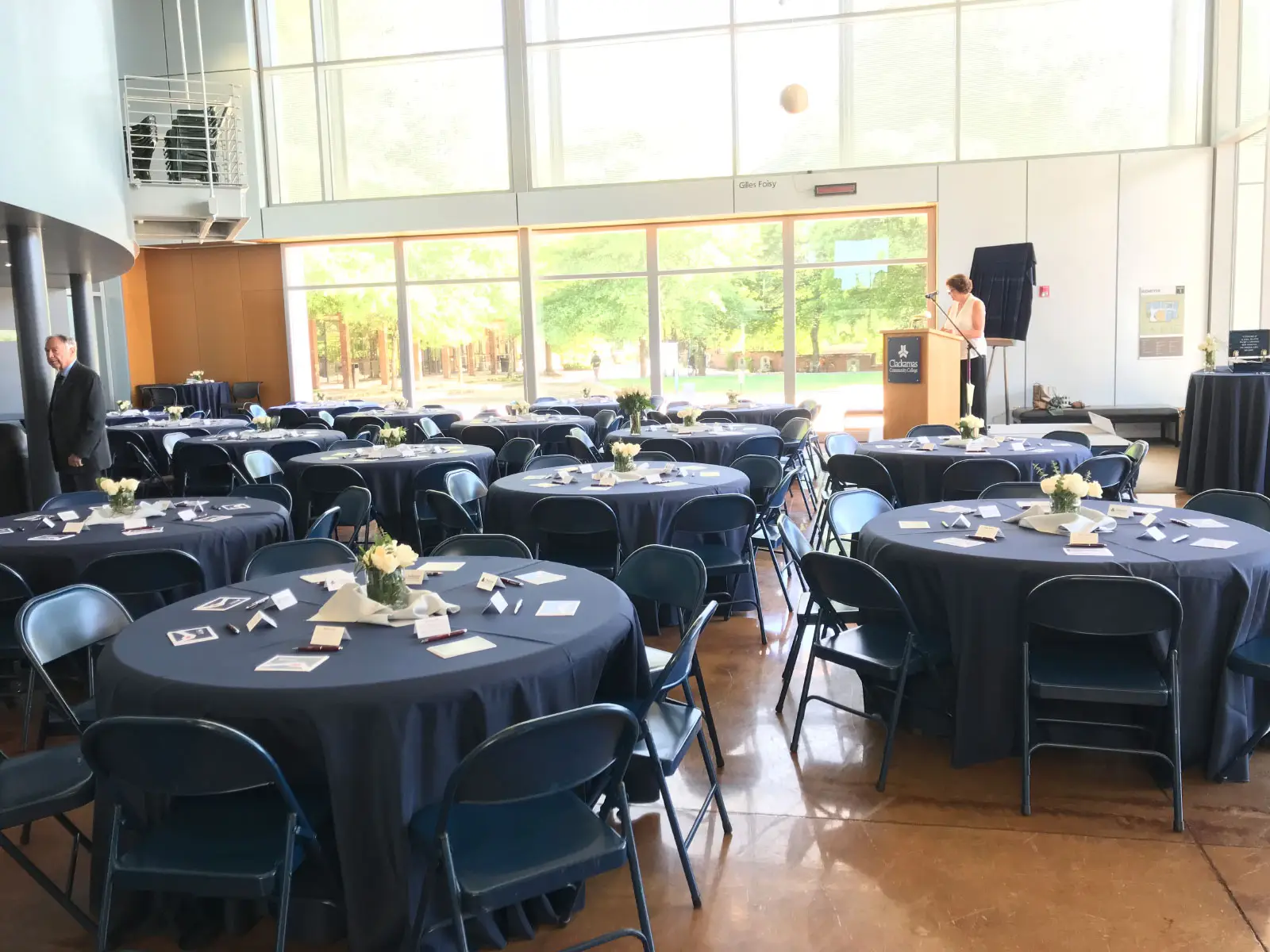 Decorated tables and podium for an event in Niemeyer Center's open lobby at the Oregon CIty campus