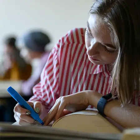 English student highlighting lines in a large literature textbook.