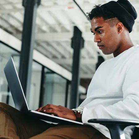 Web development student works on a project on their laptop.