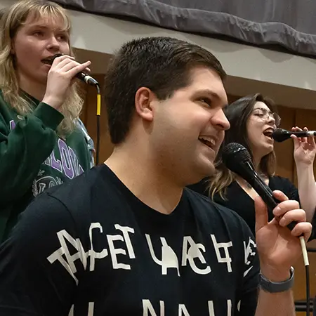 Group of music students signing together with microphones.