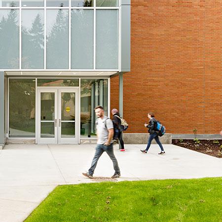 students walk in front of campus building