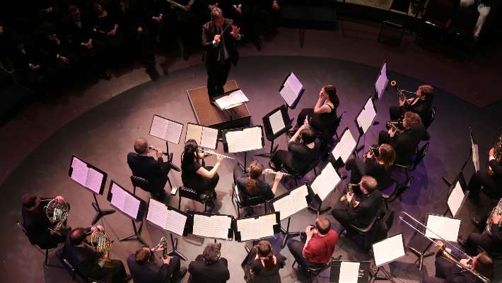 Musicians in concert with the conductor playing